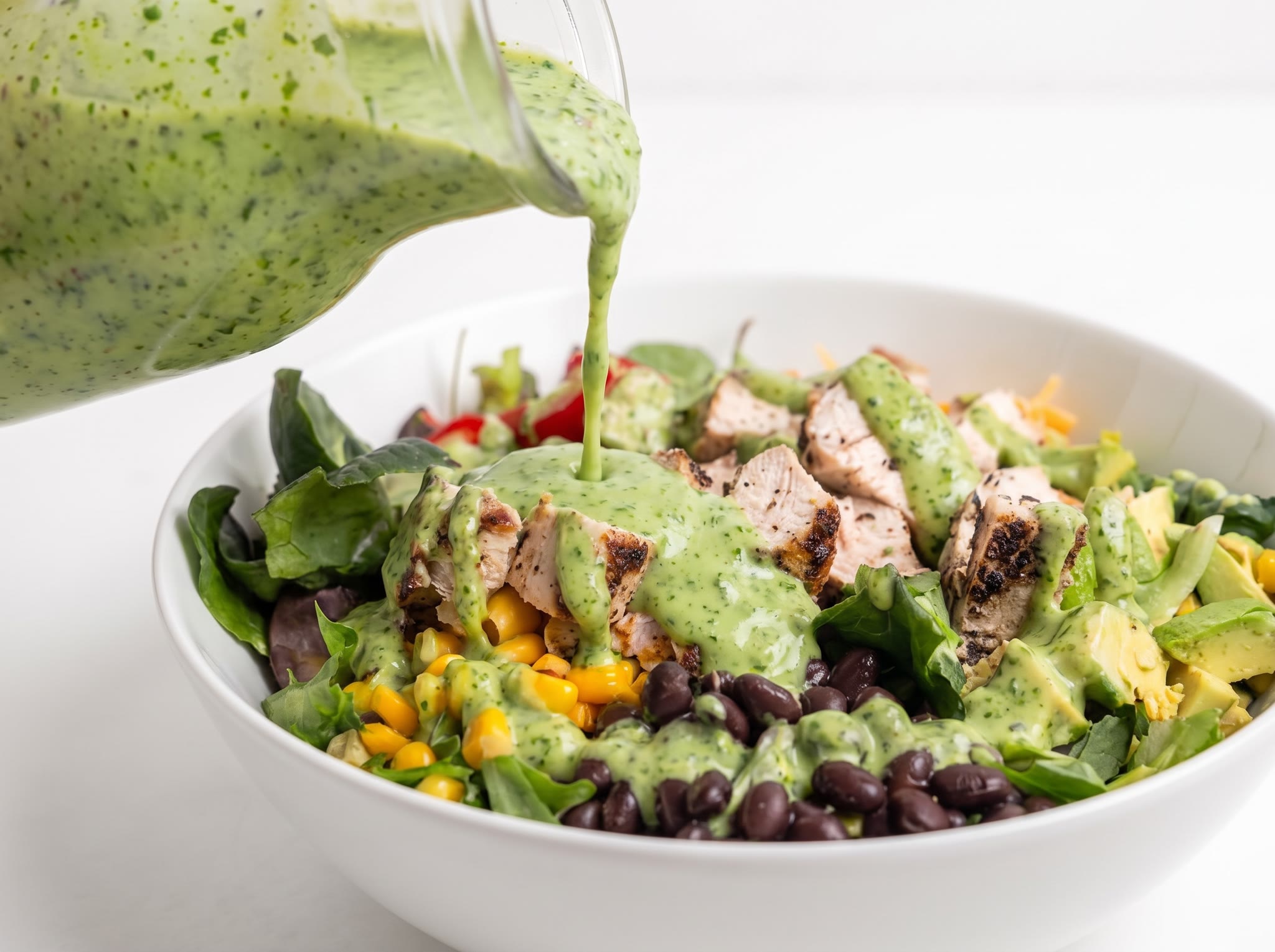 Avocado cilantro vinaigrette served over a colorful quinoa and vegetable salad